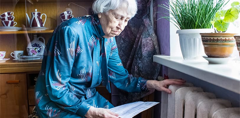 A senior woman reading her bills at home A senior woman reading her bills at home
