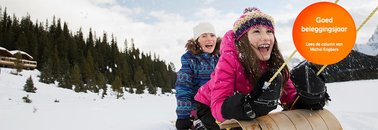 meiden in de sneeuw. Oranje bol met tekst: Goed beleggingsjaar. Lees de column van Michel Engbers