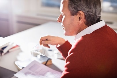 man zit met documenten aan bureau man zit met documenten aan bureau