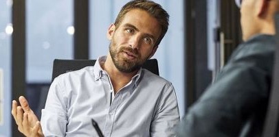 2 mannen die met elkaar in gesprek zijn op een kantoor 2 mannen die met elkaar in gesprek zijn op een kantoor