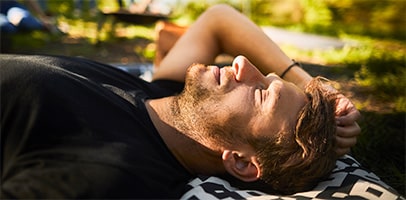 Relaxte jonge man ligt in gras Relaxte jonge man ligt in gras