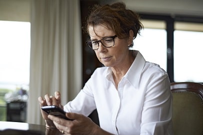 Vrouw zit met smartphone in haar hand Vrouw zit met smartphone in haar hand