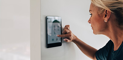 Vrouw stelt thuis haar thermostaat in Vrouw stelt thuis haar thermostaat in