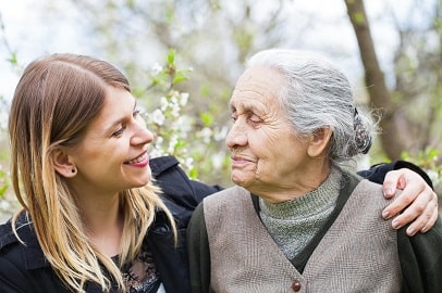 Jonge vrouw slaat arm om oude vrouw heen Jonge vrouw slaat arm om oude vrouw heen